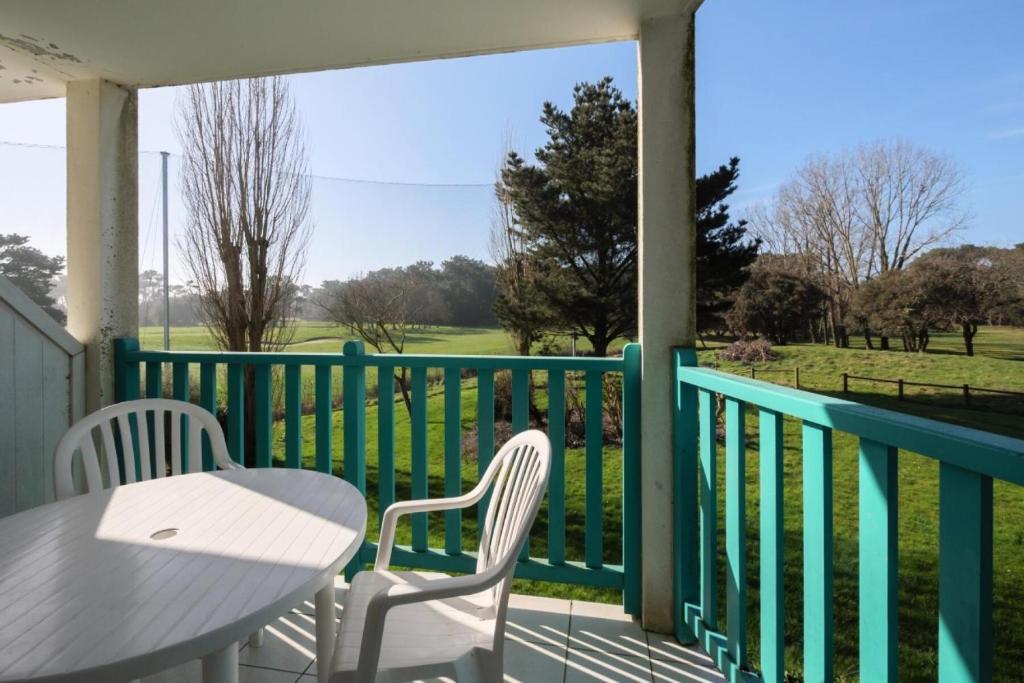 un porche avec une table et des chaises et une vue sur le parcours de golf dans l'établissement Résidence Port Bourgenay - maeva Home - Appartement 2 Pièces 5 Personnes - Sélection MAE-8605, à Talmont-Saint-Hilaire