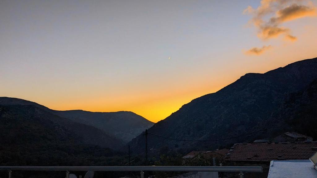 a sunset over a mountain range with the sun setting at Viva Elafonisi in Plokamianá