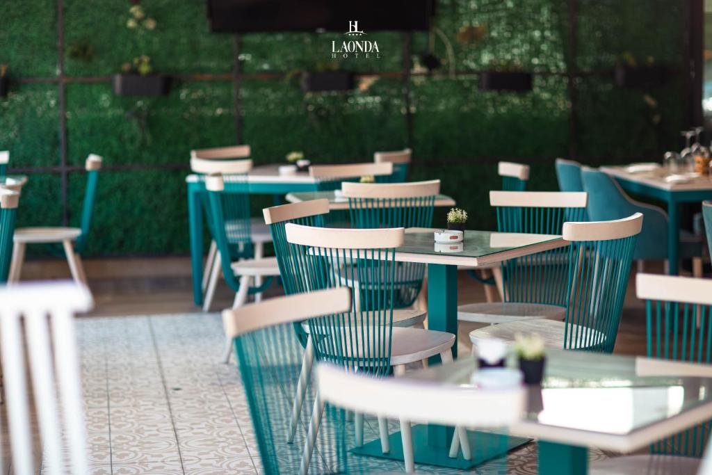 a group of tables and chairs in a restaurant at La Onda Hotel Durres in Durrës