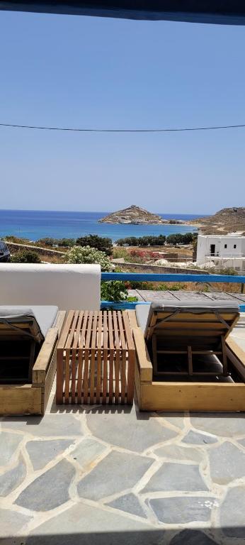 two wooden benches sitting on top of a patio at Chaniotis Studios in Kalafatis