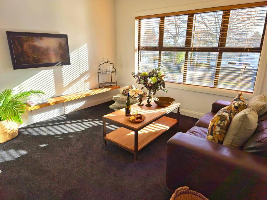 a living room with a couch and a table at Apartment 2 - Haddin Court - Stunning Executive in Blenheim