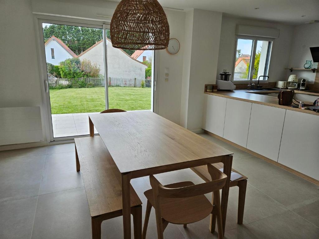 une cuisine avec une table et des chaises en bois ainsi qu'une fenêtre dans l'établissement CAP GRIS NEZ Maison 6 pers, à Audinghen