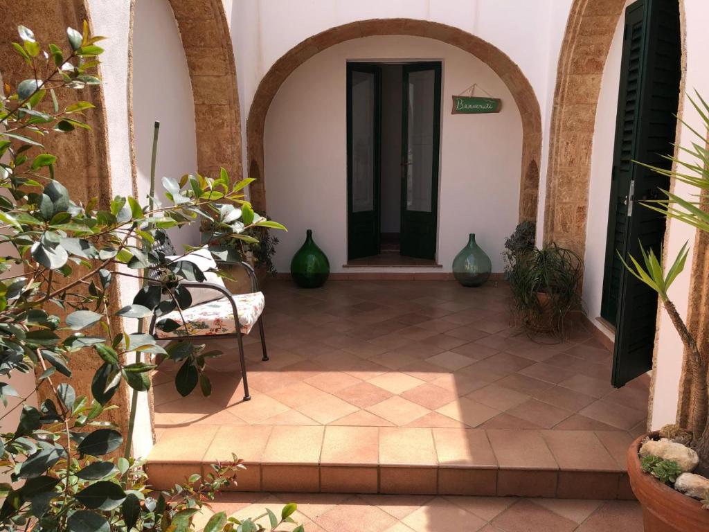 una entrada a un edificio con una silla y plantas en Lo Studio - Camilla's Guesthouse, en Morciano di Leuca