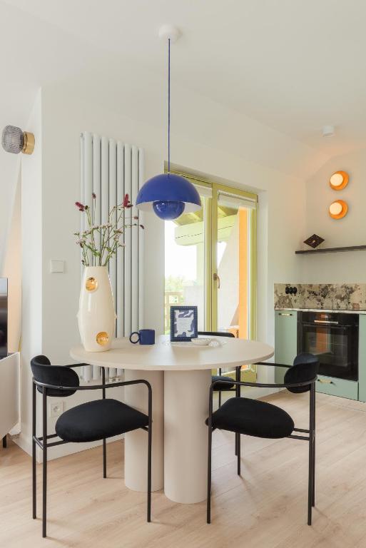 a kitchen with a table with chairs and a blue light at Sopot M17 - by JWPM in Sopot