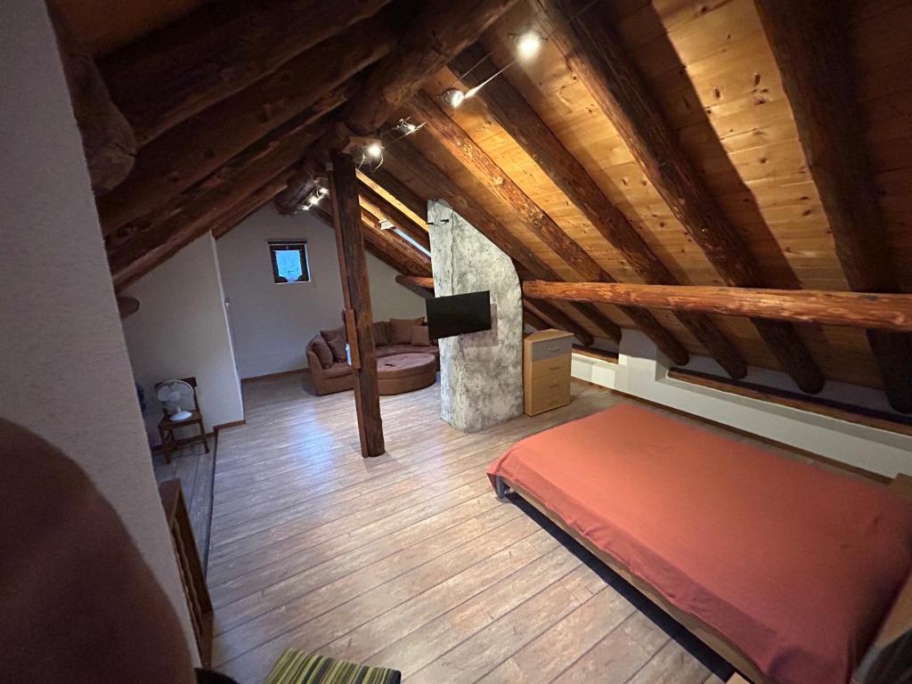 an attic room with a bed and a fireplace at Rustico Cà Laura in Brione