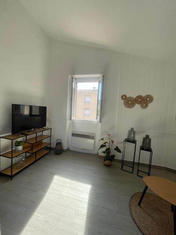 un salon avec une télévision à écran plat et une fenêtre dans l'établissement Appartement proche plage et centre ville, à Saint-Laurent-du-Var