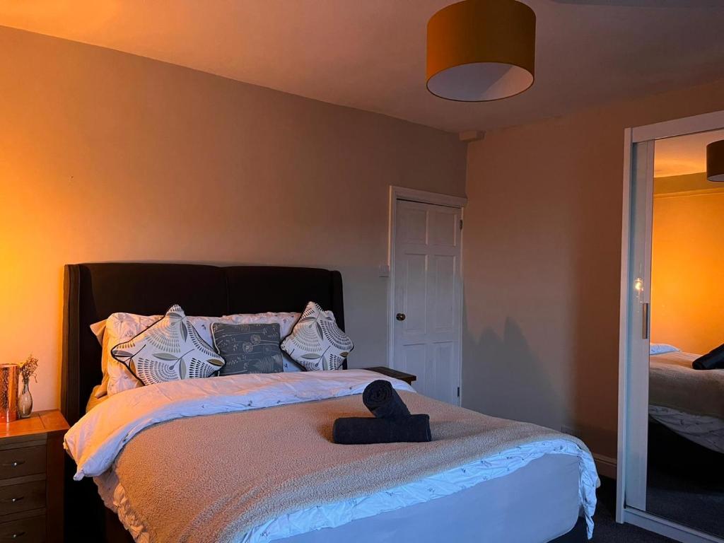 Cosy Gem in the heart of Glossop في جلوسوب: غرفة نوم مع سرير مع لوحة سوداء للرأس