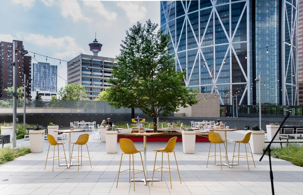 een terras met tafels en gele stoelen in een stad bij Delta Hotels by Marriott Calgary Downtown in Calgary
