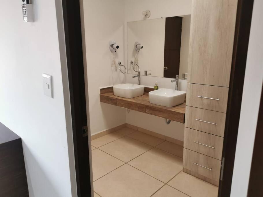 Un baño con dos lavabos y un espejo. en Tu casa en Mazatlán,, en La Florida