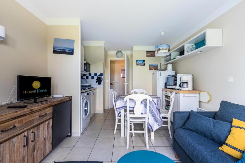 un salon avec un canapé bleu et une cuisine dans l'établissement Résidence Port Bourgenay - maeva Home - Maison 2 pièces 4 personnes - Sélection MAE-5174, à Talmont-Saint-Hilaire