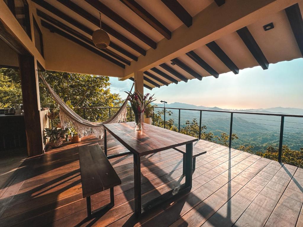 a table and a chair on a balcony with a view at Villa Canopy Minca in Minca