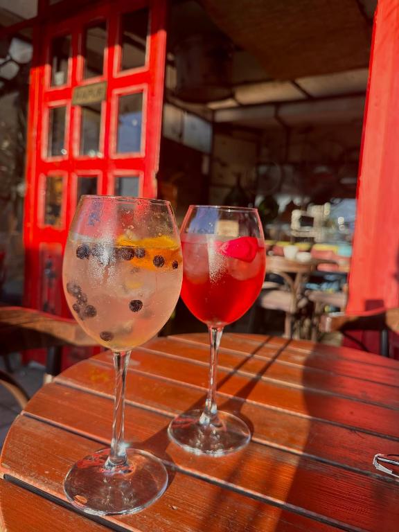 two wine glasses sitting on top of a wooden table at Divina Hostel in Tirana