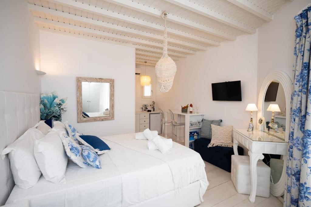 ein weißes Schlafzimmer mit einem Bett und einem Schreibtisch in der Unterkunft Fino Amore in Megali Ammos