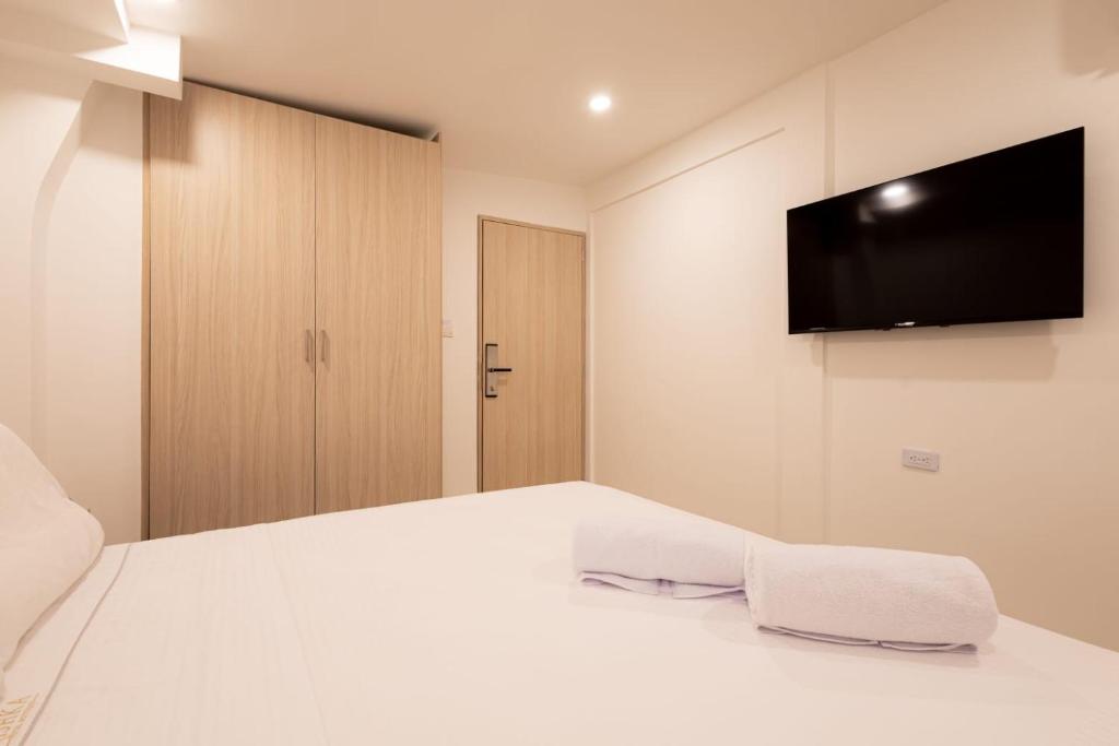 a bedroom with a white bed with a flat screen tv at Casa Mishka Hotel Boutique Habitación #104 Nuevo Cartagena in Cartagena de Indias