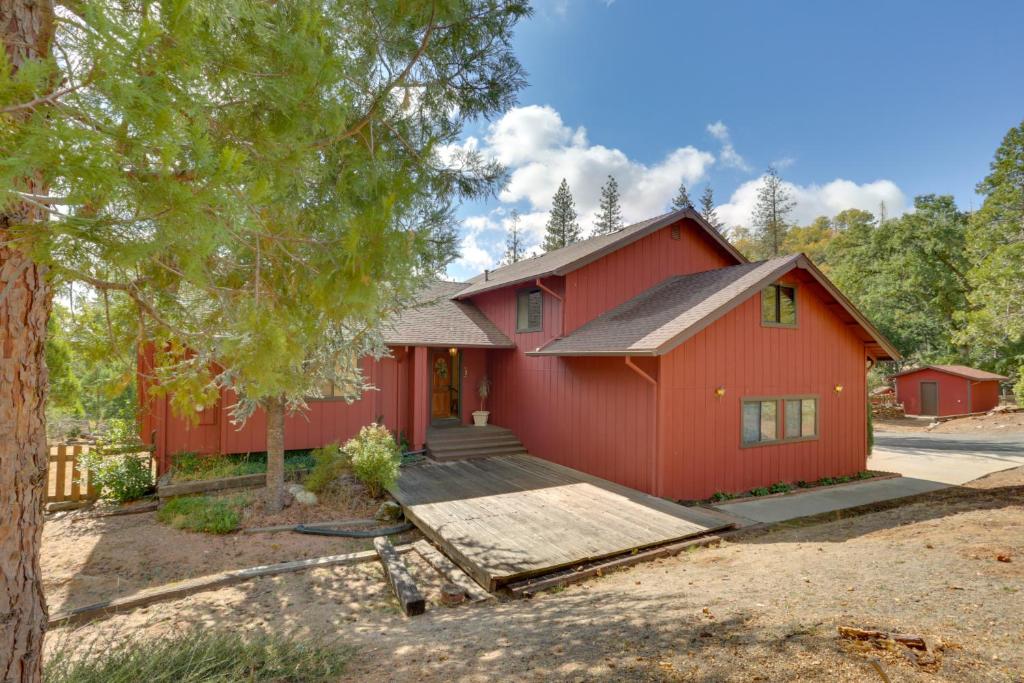 a red house with a tree in front of it at Pet-Friendly Escape with Game Room and Fire Pit! in North Fork