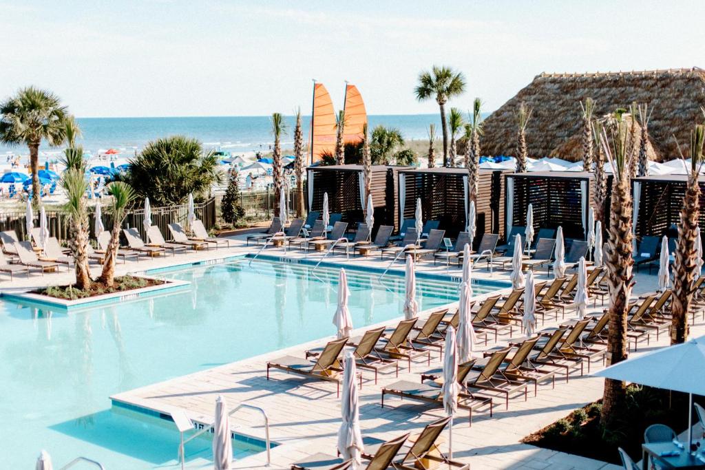 希爾頓頭島的住宿－Beach House Resort Hilton Head Island，一个带躺椅的游泳池和海洋