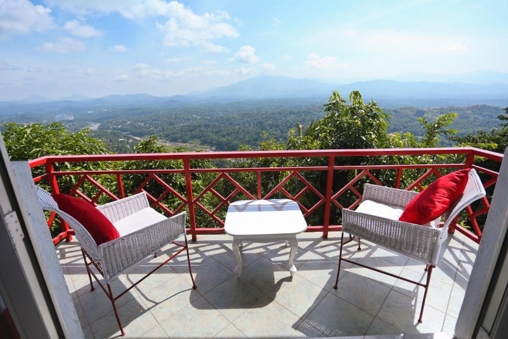 two chairs and a table on a balcony with a view at RedHill Kandy in Kandy