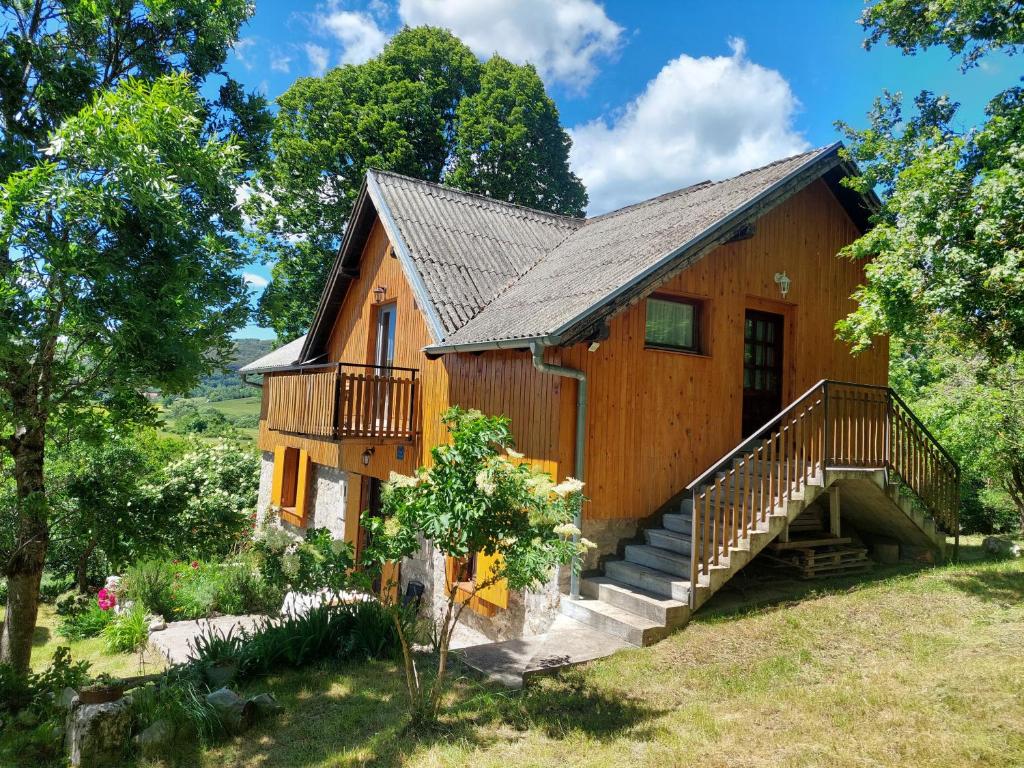 a log cabin with stairs and a porch at Guest house Griva Plitvice in Korenica
