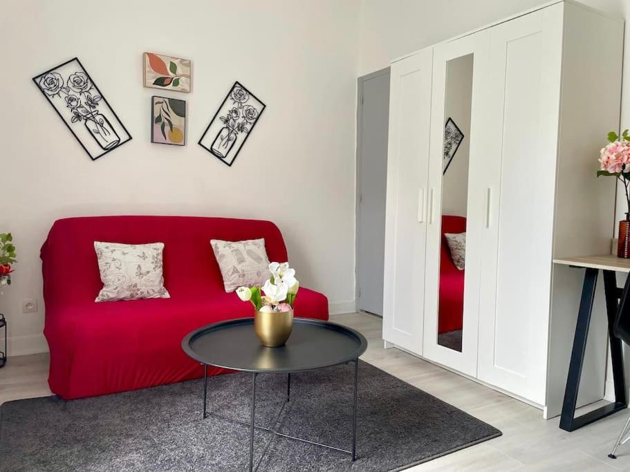 un soggiorno con un divano rosso e un tavolo di Cosy au Cœur de Dijon a Digione