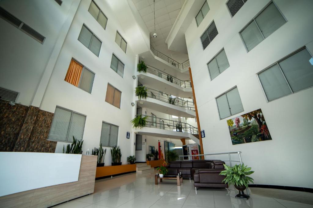 a lobby of a building with couches and plants at Apartahotel cerca del Parque del Café, 405A in Montenegro