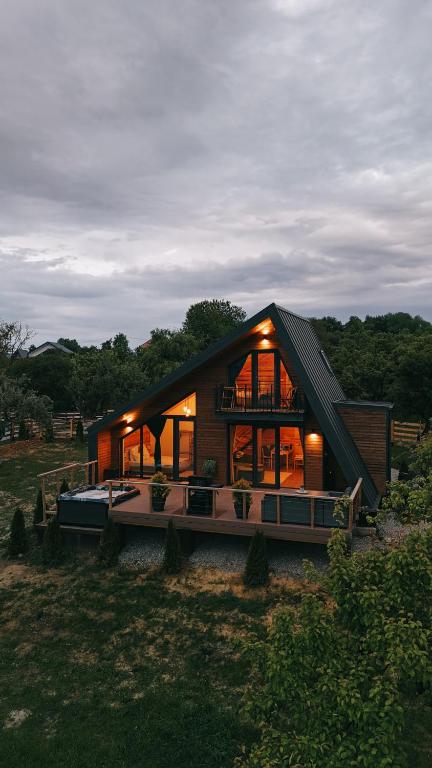 ein großes Holzhaus mit vielen Fenstern in der Unterkunft Zenit Chalet-Bran in Sohodol