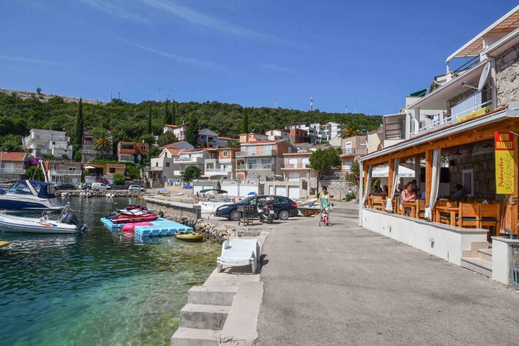 a restaurant next to a marina with boats in the water at Apartments by the sea Duboka, Neretva Delta - Usce Neretve - 23268 in Klek