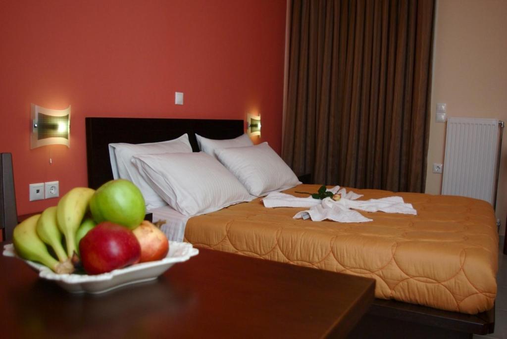 a hotel room with a bed with fruit on a table at Xenonas Ioanni Parcha in Levidi