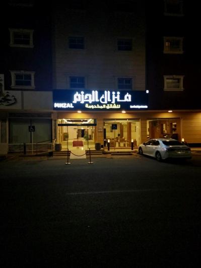 a car parked in front of a building at night at منزال الحزم للشقق المخدومة in Ar Rass