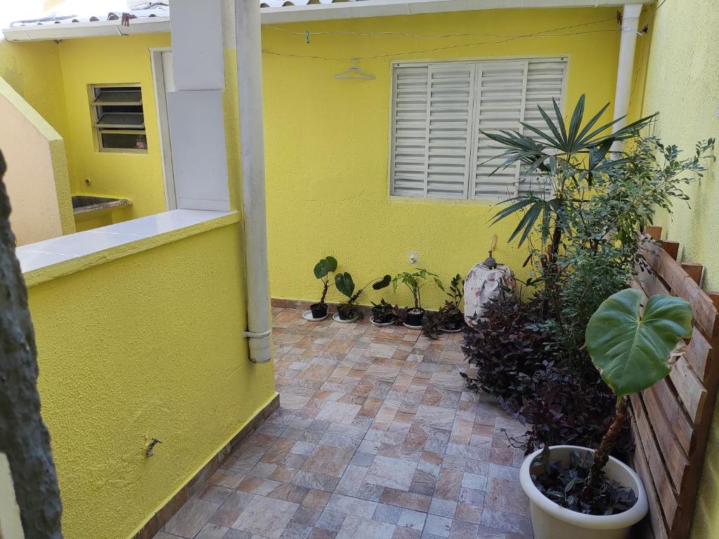 uma parede amarela com um monte de vasos de plantas em Agradavel casa familiar proxima Expo SP e metro Jabaquara em São Paulo
