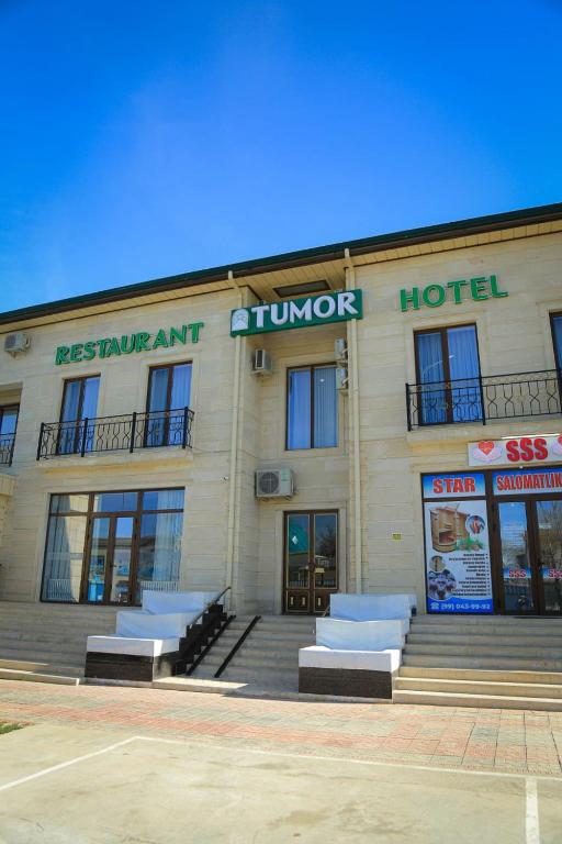 a building with a tumnor hotel with stairs in front at Гостиница Тумор in Shahrisabz