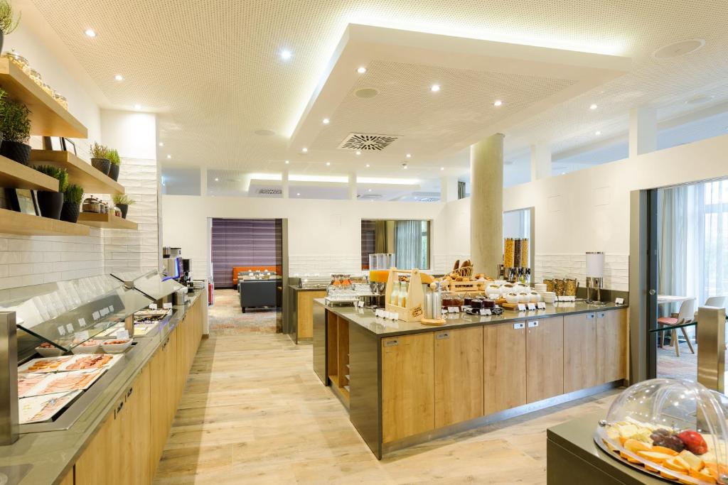 a restaurant with a buffet line in a cafeteria at Novotel München City Arnulfpark in Munich