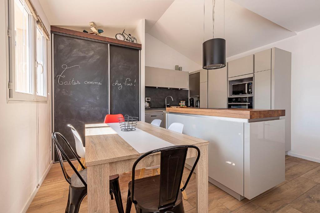 uma cozinha com uma mesa e um quadro negro em MEET - AIRBUS - TRAMWAY em Aussonne