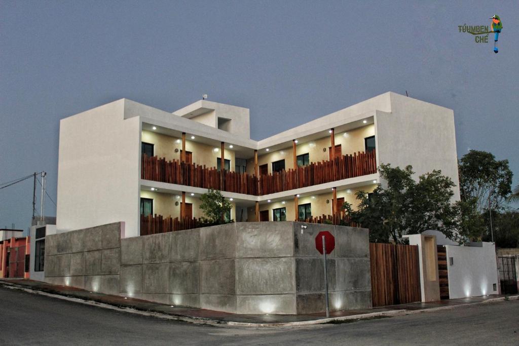 a white house with a fence in front of it at Departamentos Túumben Ché in Valladolid