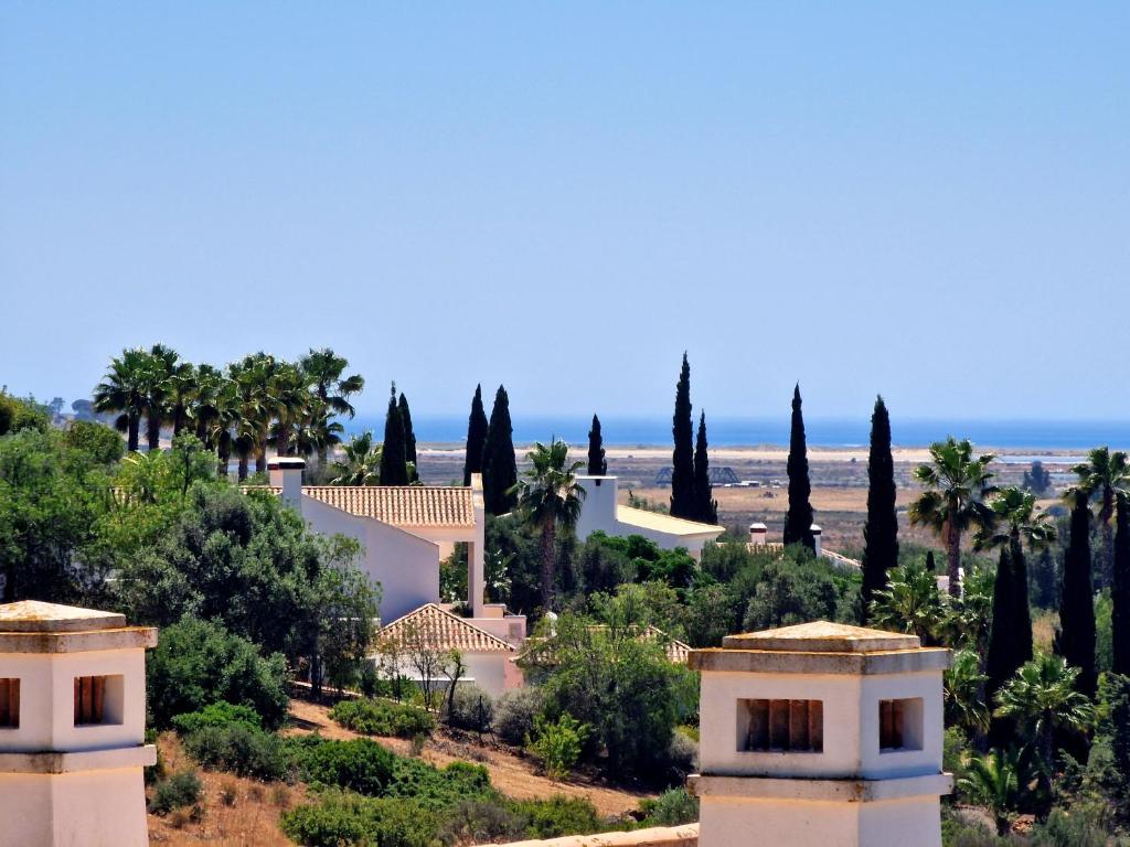 a house on a hill with trees and the ocean at Villa Marcia Home - Nature, Golf, Beaches-Lagos in Portimão