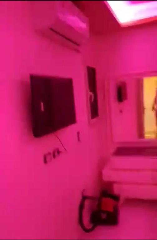 a pink room with a tv on a wall at الفايق للشقق الفندقيه 11 in Cairo