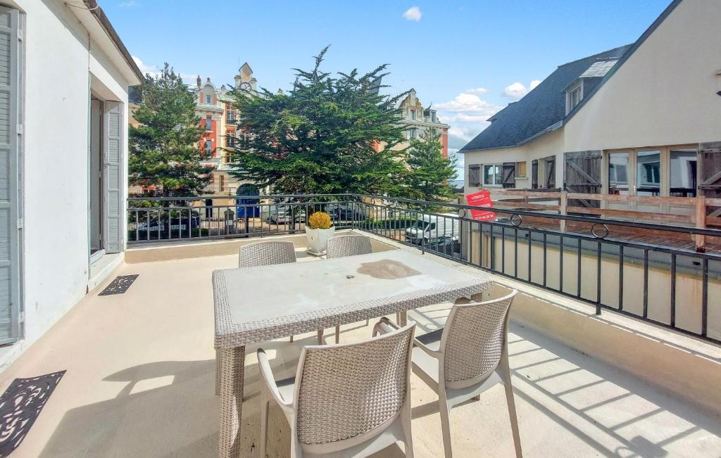 Un patio con una mesa y sillas en un balcón. en Gorgeous Apartment In Saint-Lunaire, en Saint-Lunaire
