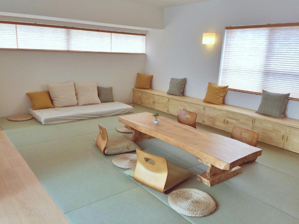 uma sala de estar com uma mesa e um sofá em Guest House Ishigaki em Ishigaki