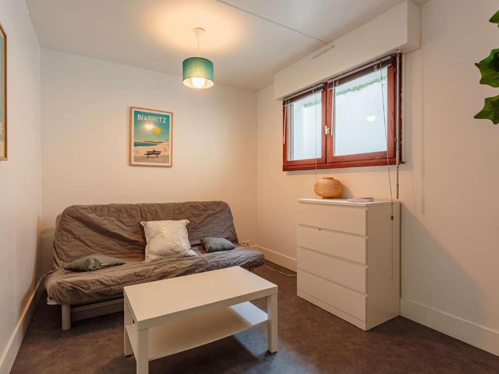 un salon avec un canapé et une table dans l'établissement Studio rénové avec piscine, Wi-Fi, proche centre ville et plage - FR-1-3-610, à Biarritz