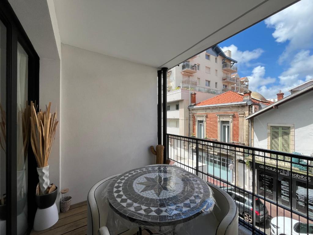 d'un balcon avec une table et une grande fenêtre. dans l'établissement Arcachon Centre : T2 avec Parking, Loggia et Proche Plage - FR-1-319-566, à Arcachon