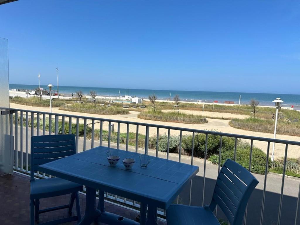 einen blauen Tisch und Stühle auf einem Balkon mit Strand in der Unterkunft Studio vue mer à Notre-Dame-de-Monts - Animaux OK, Parking - 2 pers. - FR-1-540-292 in Notre-Dame-de-Monts