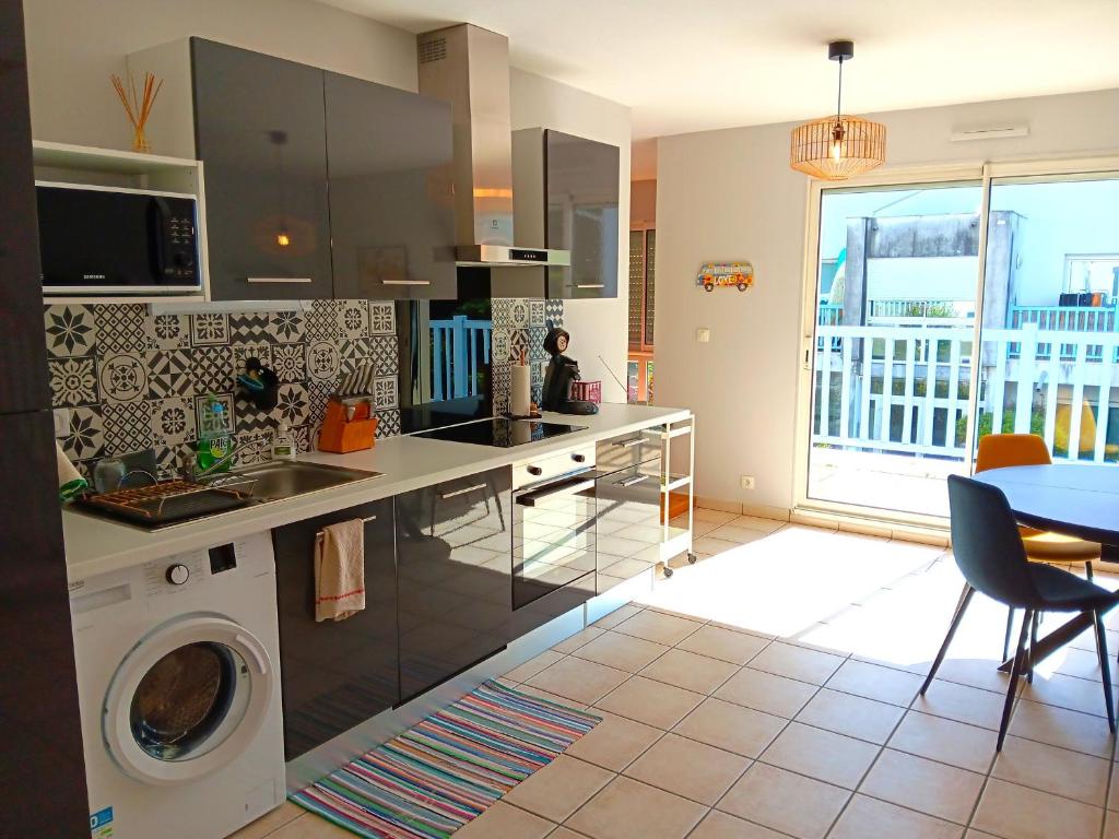 une cuisine avec un évier et une machine à laver dans l'établissement Appartement lumineux proche centre et plage avec terrasse et parking, Capbreton - FR-1-239-1056, à Capbreton