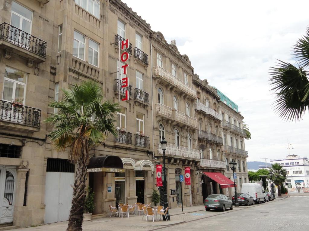 un edificio con una palmera delante de él en Hotel Compostela Vigo, en Vigo