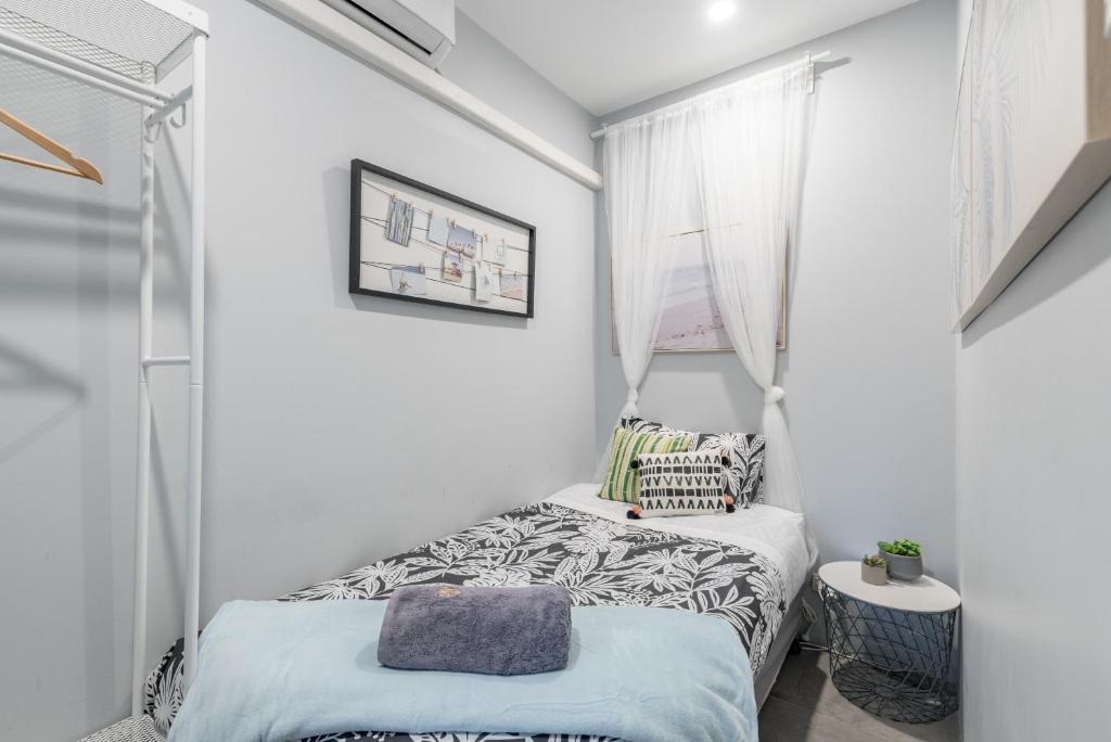 a small bedroom with a bed and a window at Modern Single Room - AC - 1Min Walk to Central- Close to Darling Harbour Chinatown CBD - Shared Bathroom in Sydney