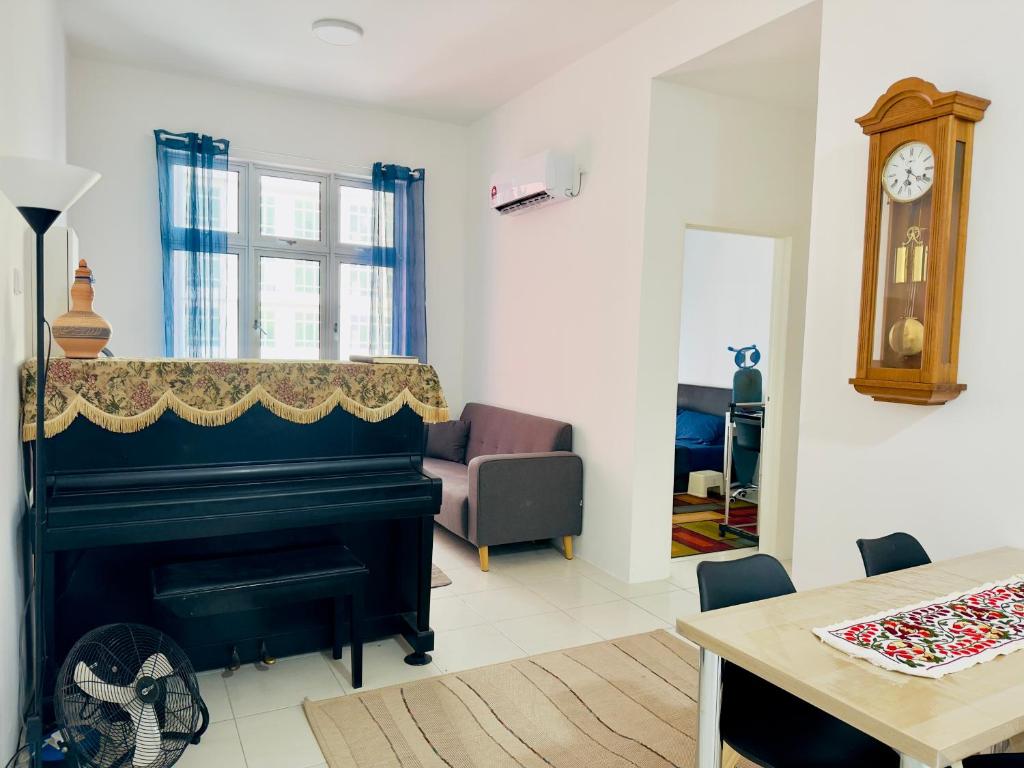 a living room with a piano and a table at A Room - Stay With the Host in Ipoh