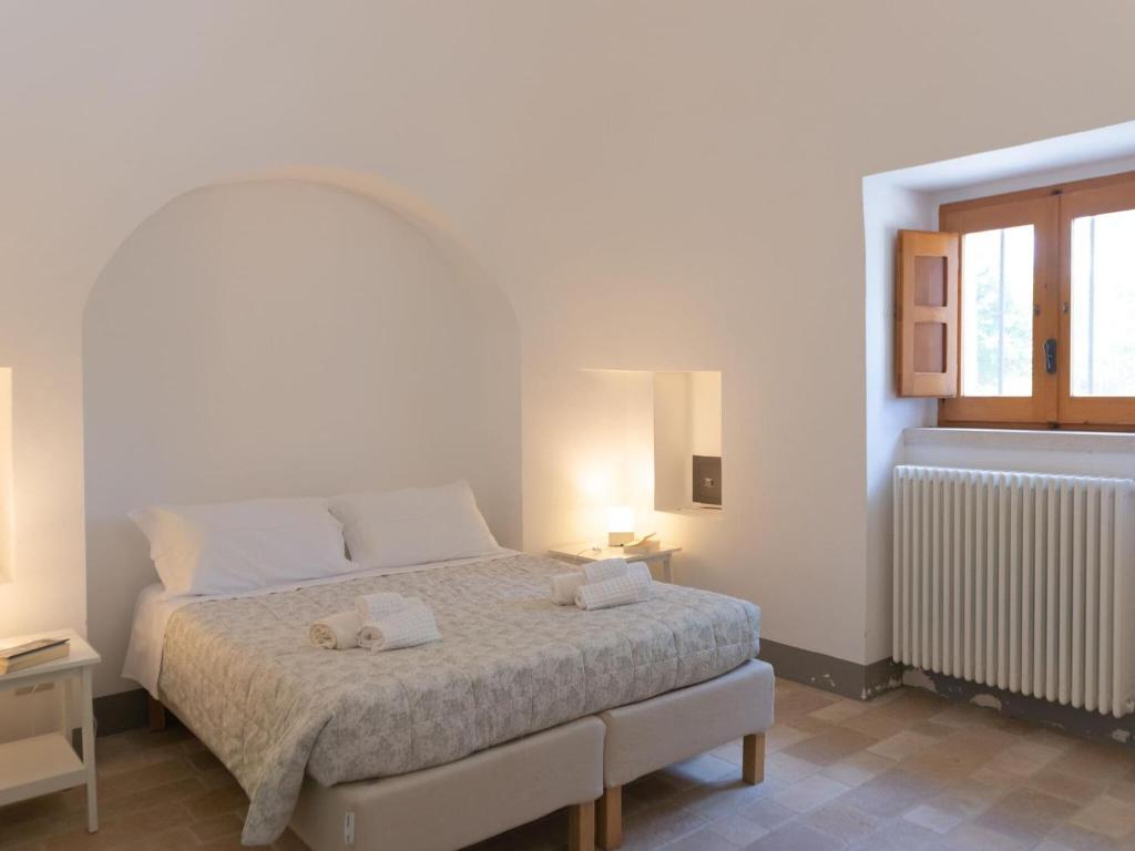 A bed or beds in a room at Historic Trulli Azzalema in Cisternino