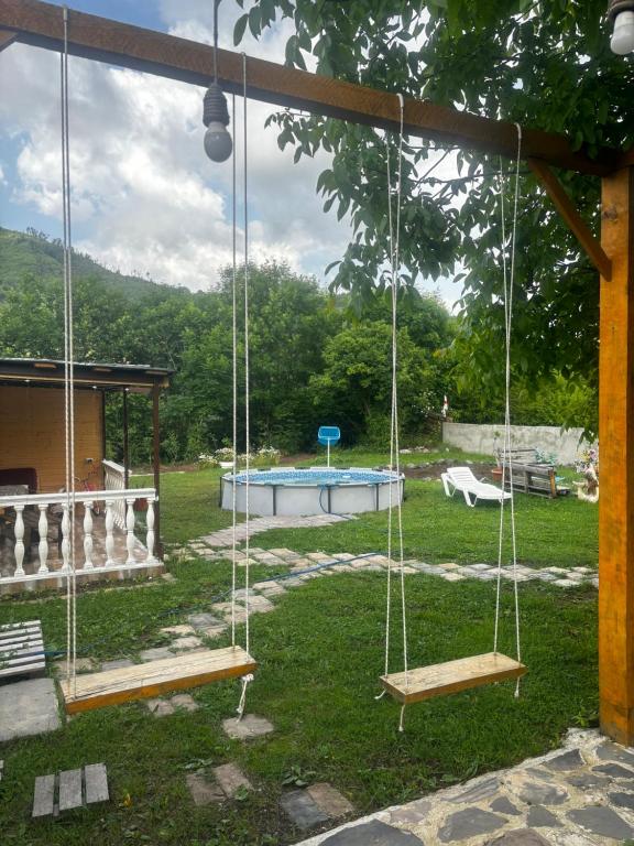a swing set in a yard with a pool at Kesi’s House in Borjomi