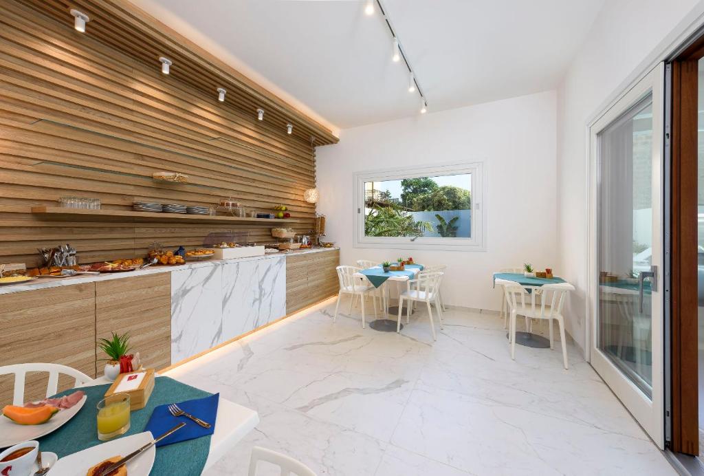a kitchen with wooden walls and tables and chairs at Andromeda Hotel in San Vito lo Capo