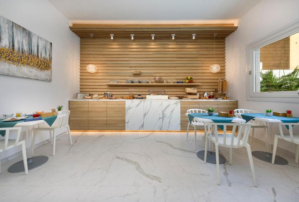 a kitchen with tables and chairs and a counter at Andromeda Hotel in San Vito lo Capo