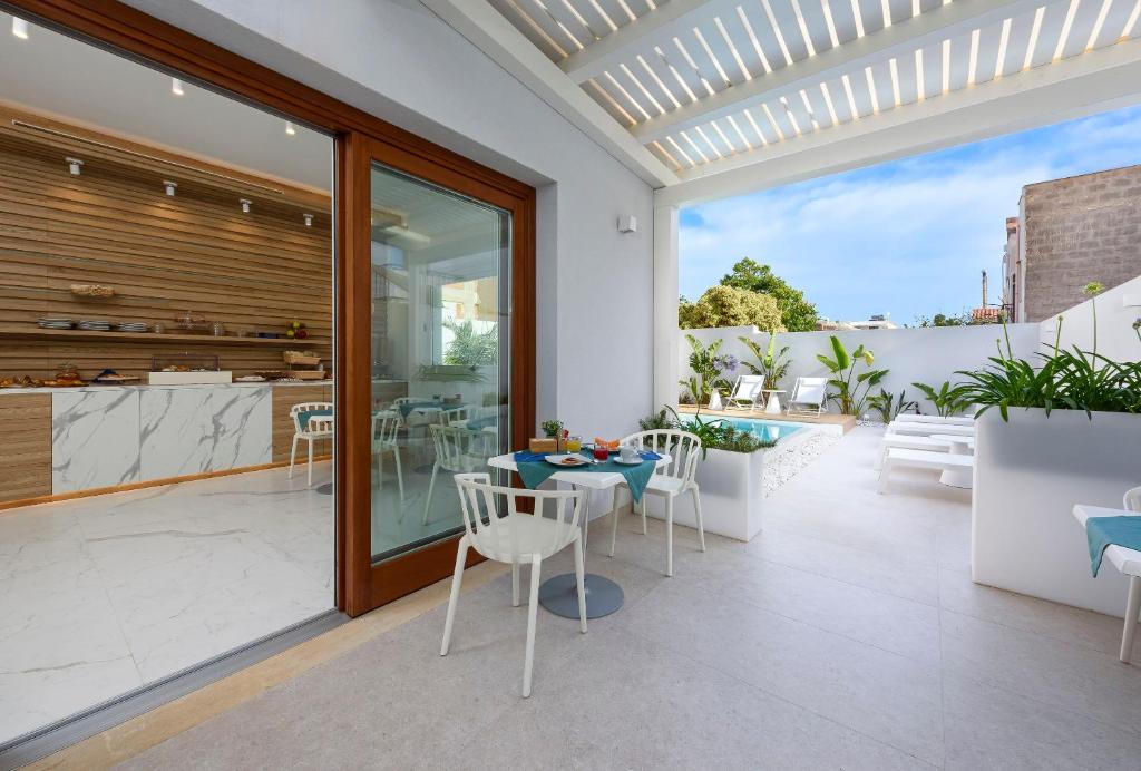 a patio with a table and chairs and a kitchen at Andromeda Hotel in San Vito lo Capo