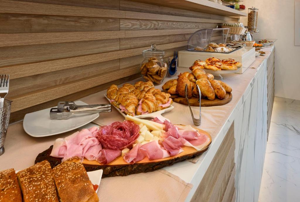 a buffet line with different types of meats and pastries at Andromeda Hotel in San Vito lo Capo